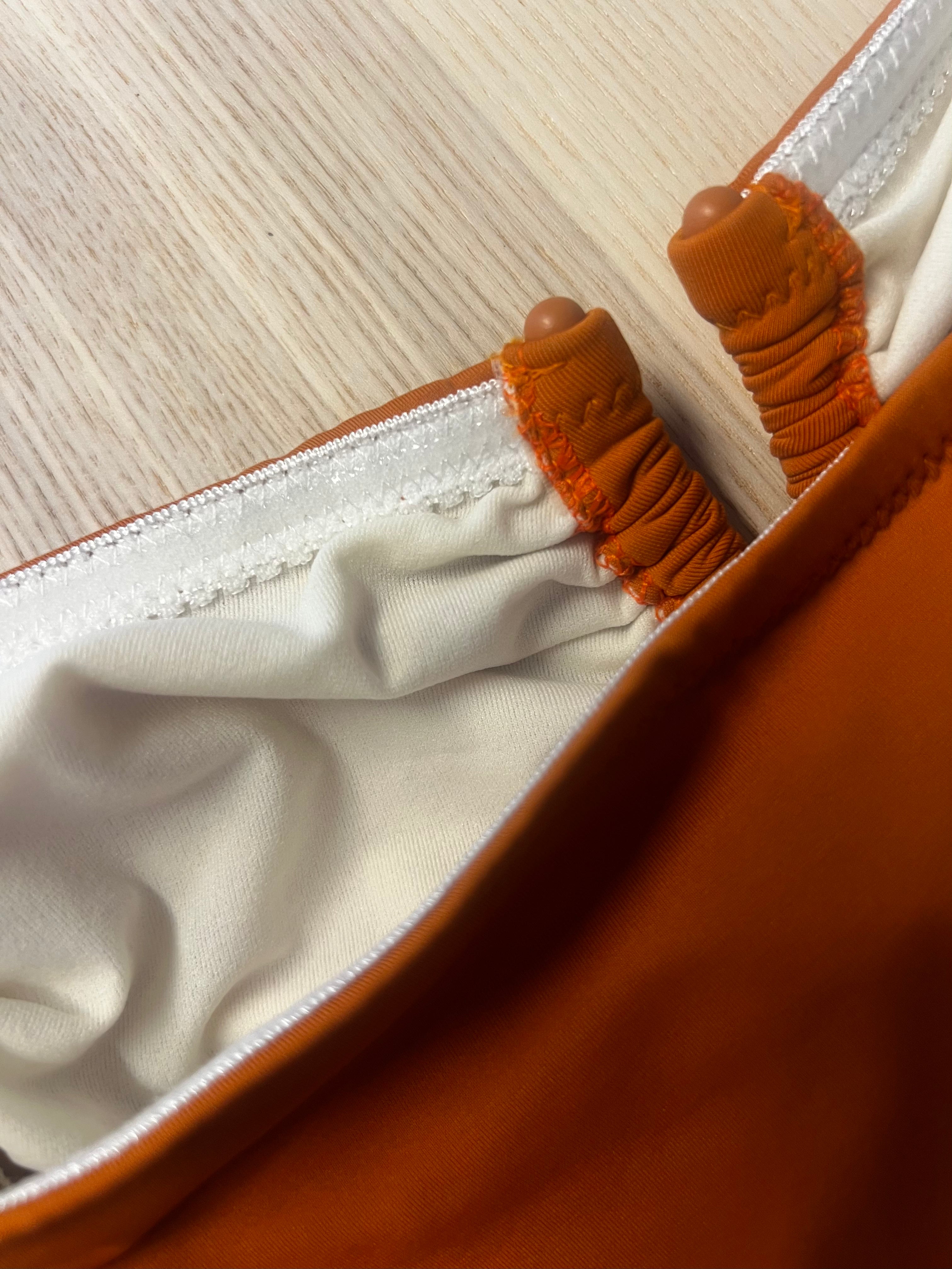 Close-up of a brown leather bag with white interior lining on a wooden surface