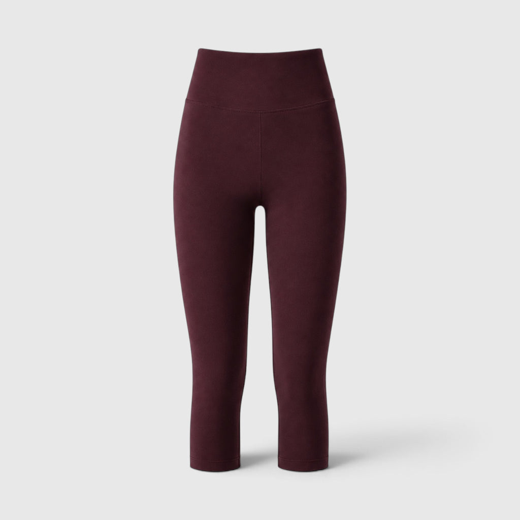 A pair of high-waisted, ankle-length leggings in a deep burgundy color, shown from the back against a light gray studio background.
