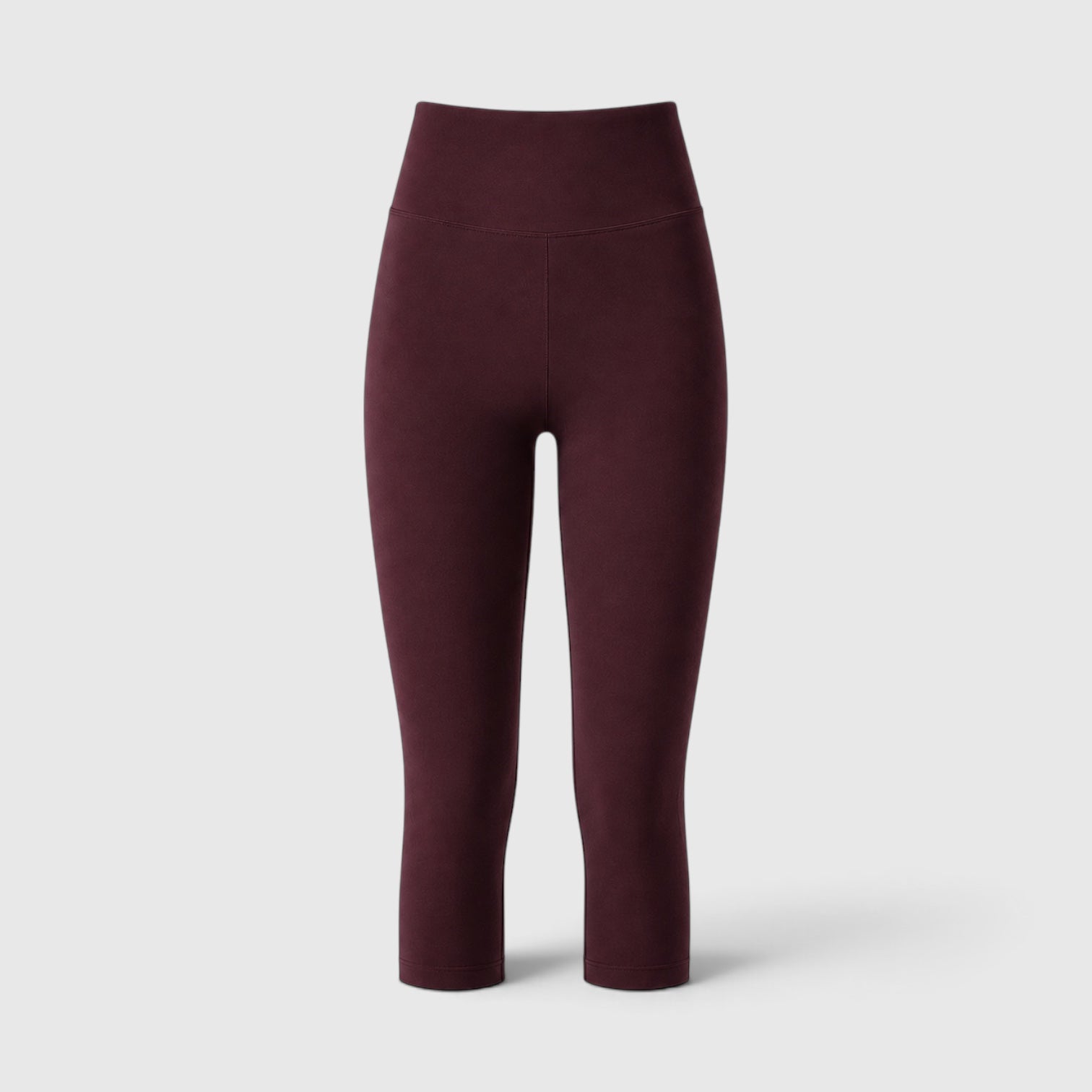 A pair of high-waisted, ankle-length leggings in a deep burgundy color, shown from the back against a light gray studio background.